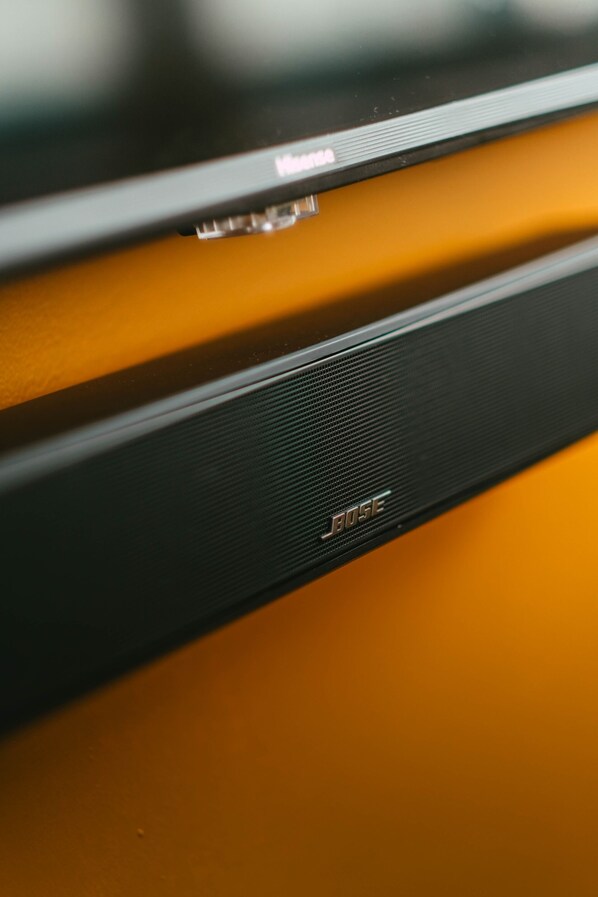 A close-up of a black electronic device with the brand name 'BOSE' on it, placed on a yellow surface. - *Penthouse* - Luxe Stay with Views - Free Parking (Halifax)