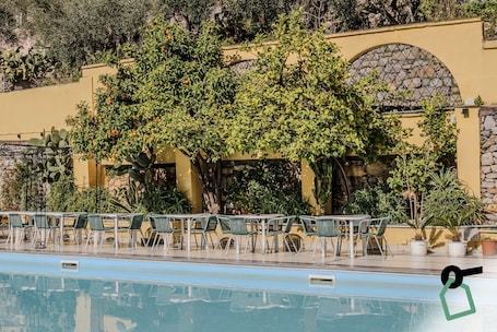 Una piscina al aire libre de temporada, sombrillas