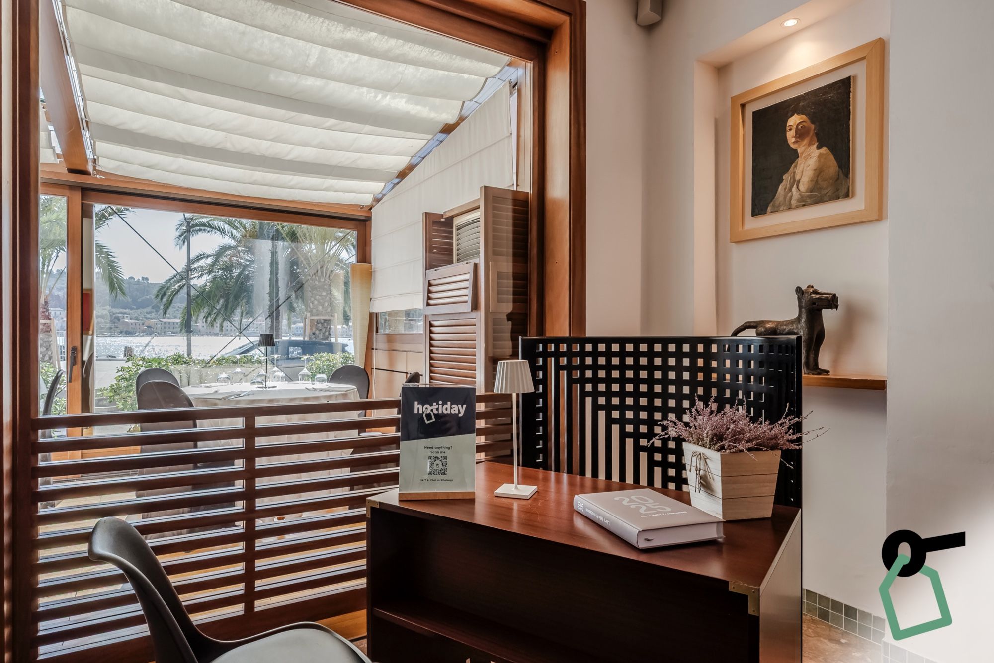A reception desk with a view of palm trees and a body of water outside.