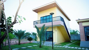 A modern two-story house with a balcony, a lawn, and a garden. - LML Kampot Relax House (Kampot)