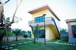 A modern two-story house with a balcony, a lawn, and a garden. - LML Kampot Relax House (Kampot)