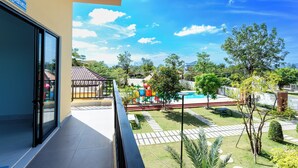 A balcony with a clear view of a swimming pool, a children's play area, and a garden. - LML Kampot Relax House (Kampot)
