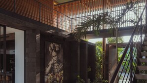 Ein modernes Interieur mit Treppe, großem Wandbild und Blick ins Freie.