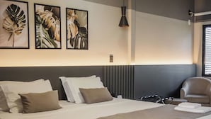 A modern hotel room with a large bed, a headboard with vertical lines, a hanging pendant light, and framed artwork on the wall. - Hotel Avenida (Sorriso)
