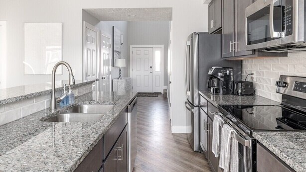 A modern kitchen with granite countertops, stainless steel appliances, and a walk-in pantry. - Relax in Style, Golf course Community Townhouse - 3440 (Baldwinsville)
