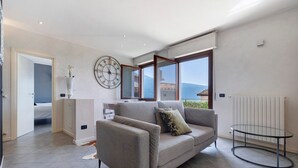 Una sala de estar moderna con un sofá, una mesa de centro de vidrio y un reloj de pared grande.