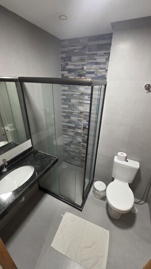Familie appartement | Badkamer | Een haardroger, handdoeken, zeep, toiletpapier