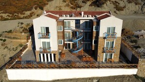 Un immeuble moderne à plusieurs étages, doté de balcons, d’un escalier en colimaçon et d’espaces de détente en plein air.
