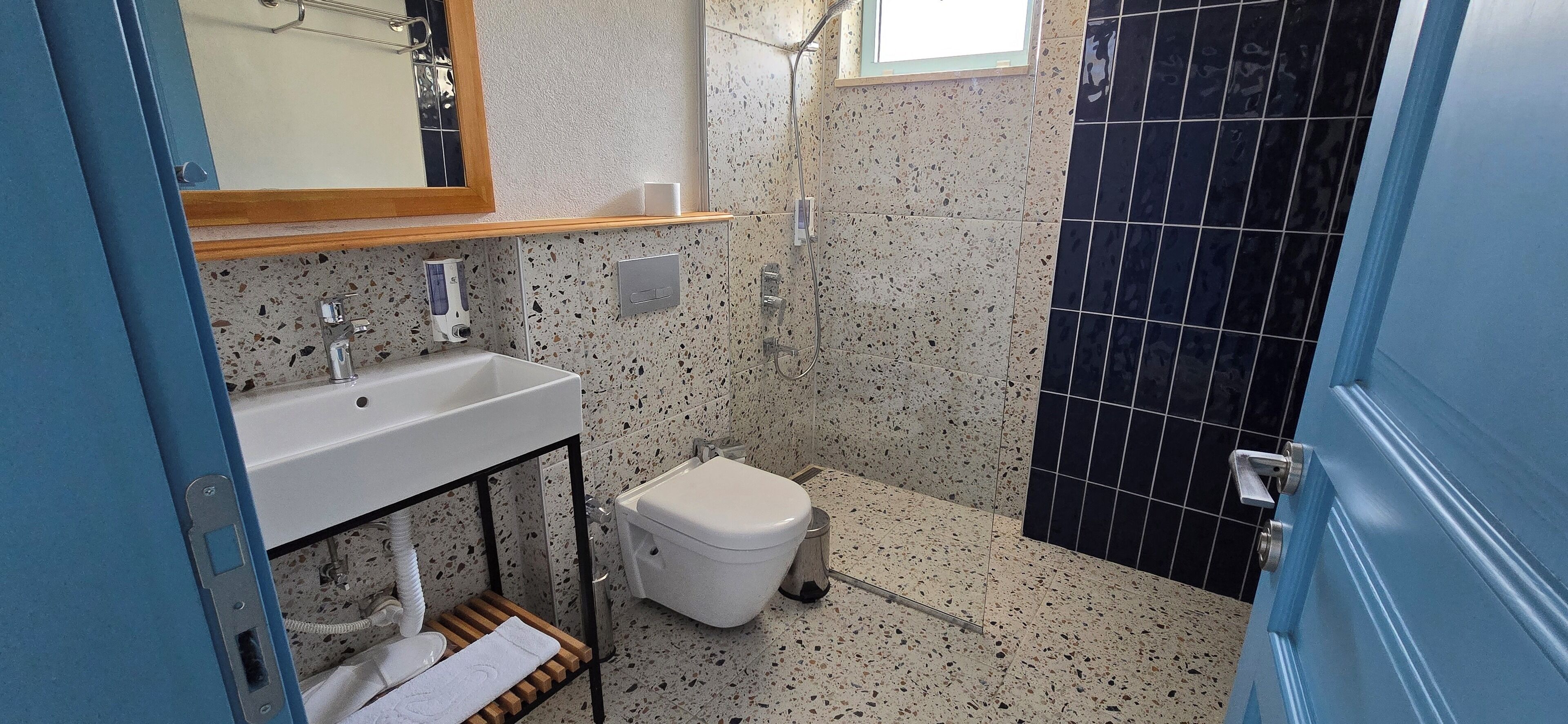 Un baño con un lavamanos blanco, un inodoro y una zona de ducha.