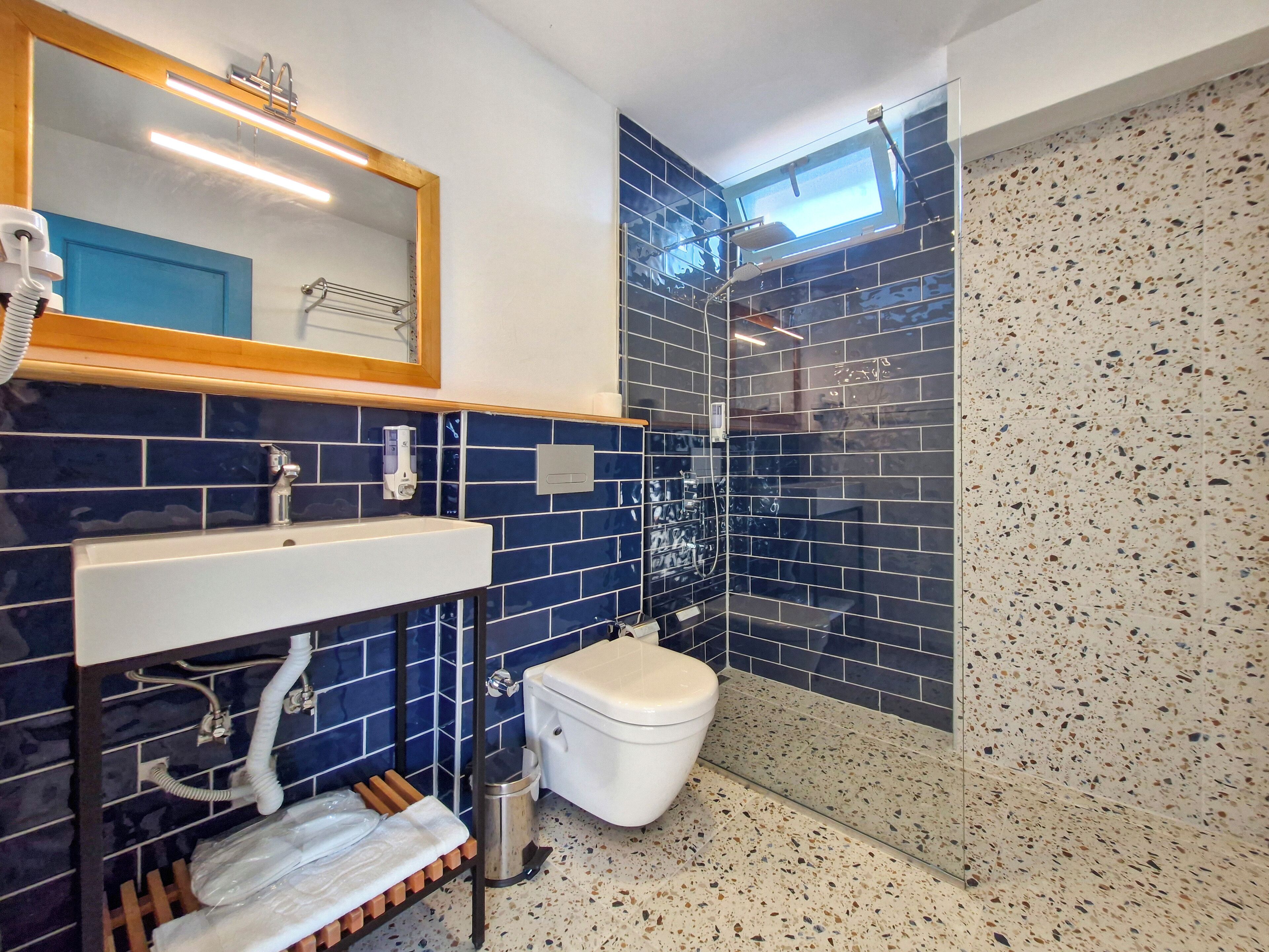 A bathroom with a white sink, a toilet, and a shower area.