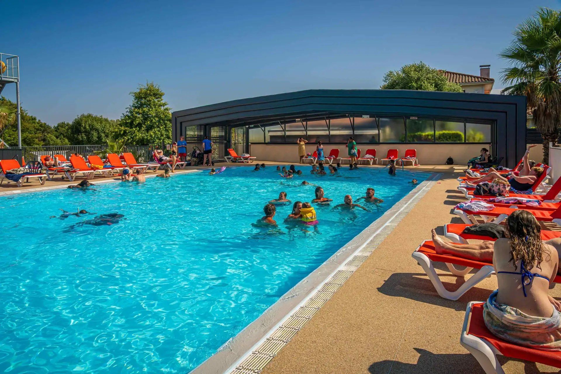 A swimming pool with people swimming and lounging.