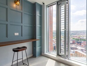 Una stanza moderna con un'ampia finestra, una panca in legno e un lampadario a parete.
