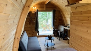 A cozy cabin with a loft-style bedroom, a dining area, and a large window offering a view of the outdoors. - ZEcamping 4* familial piscine chauffée locatif clim 15m2 (Rosans)