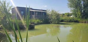 Un bâtiment doté d’un porche et d’un bassin devant l’entrée.