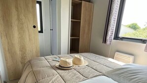 Un dormitorio con una cama grande, un armario y una ventana con cortinas.