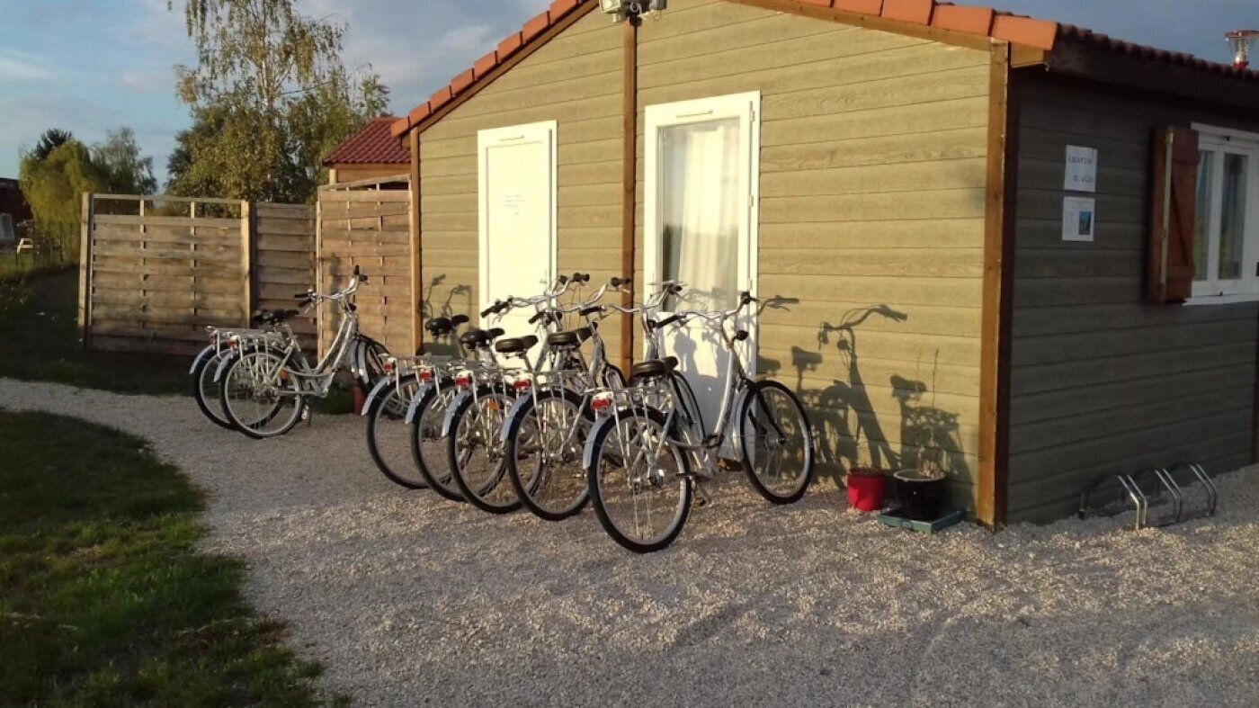 A building with a gravel driveway and bicycles parked in front.