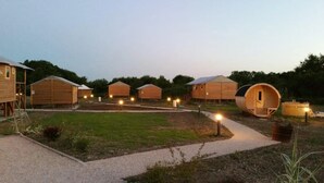 Una hilera de cabañas de madera con un camino de grava al frente.