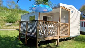 A mobile home with a wooden deck and a covered patio area. - ZEcamping 3 étoiles piscine chauffée chiens acceptés mobil-home BBQ (Lesperon)