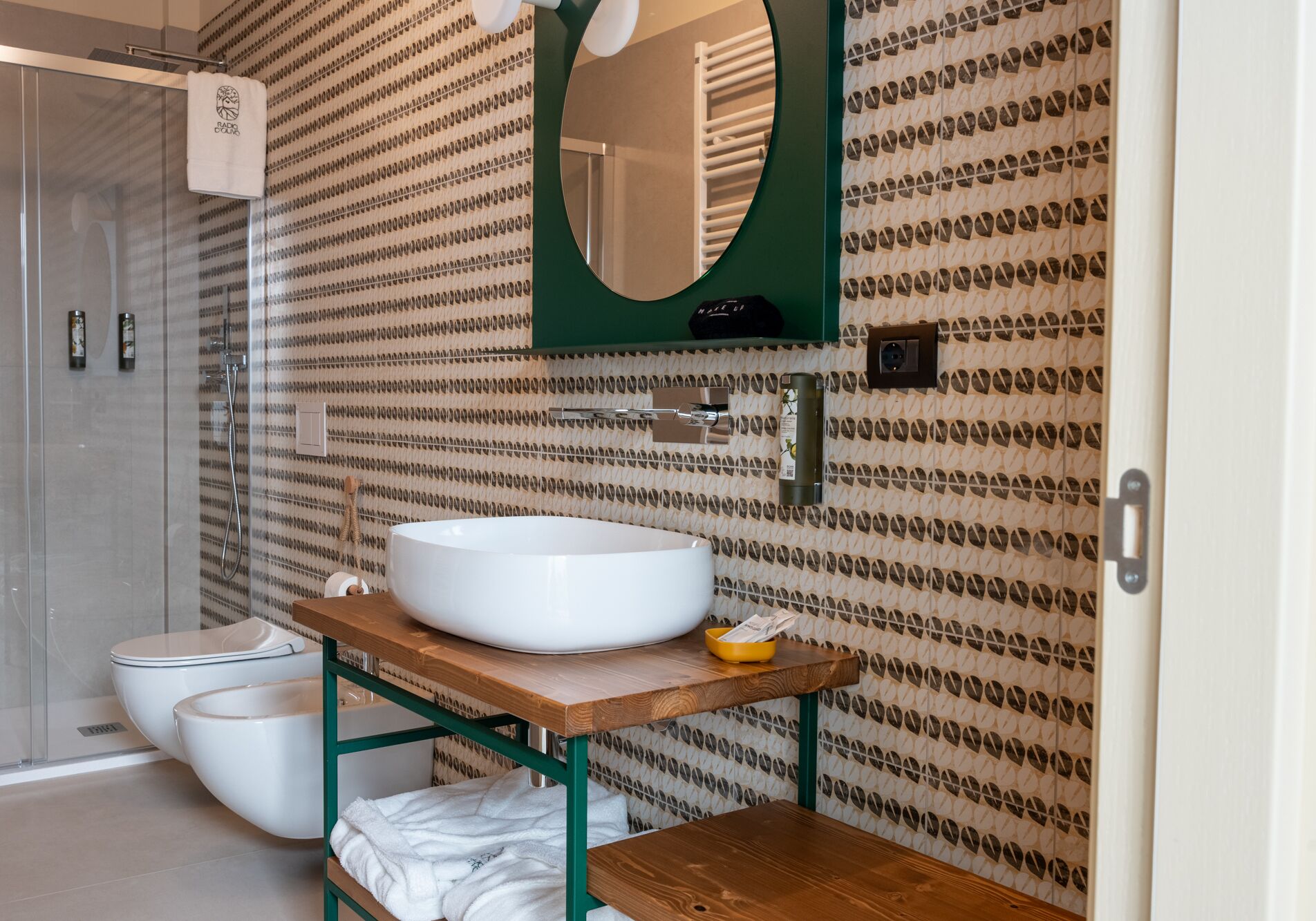 A bathroom with a large white sink, a mirror, and a shower.