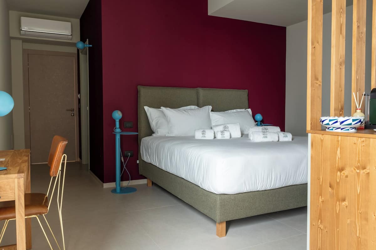 A bedroom with a bed, a desk, and a chair.
