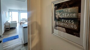 Un pasillo con un cartel enmarcado que dice "THE BEACH FIXES EVERYTHING".