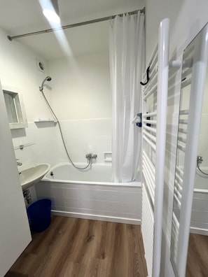 A modern bathroom with a bathtub, shower, and sink. - Apartment in Middelkerke With Sea View (Middelkerke)