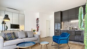 Ein modernes Wohnzimmer mit einer Couch, einem blauen Sessel und einem kleinen Couchtisch.