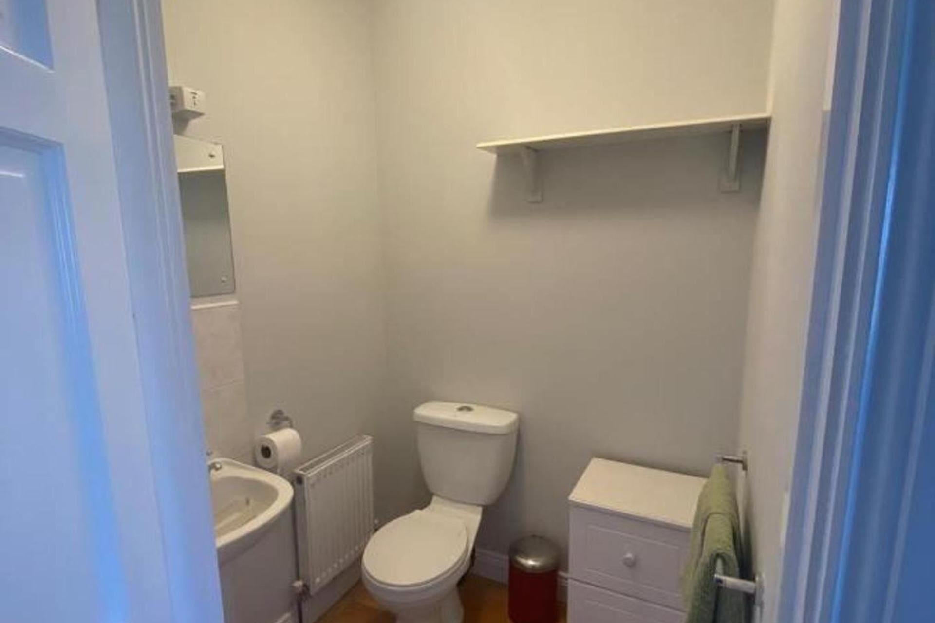 Un baño pequeño y funcional con inodoro, lavamanos y toallero.