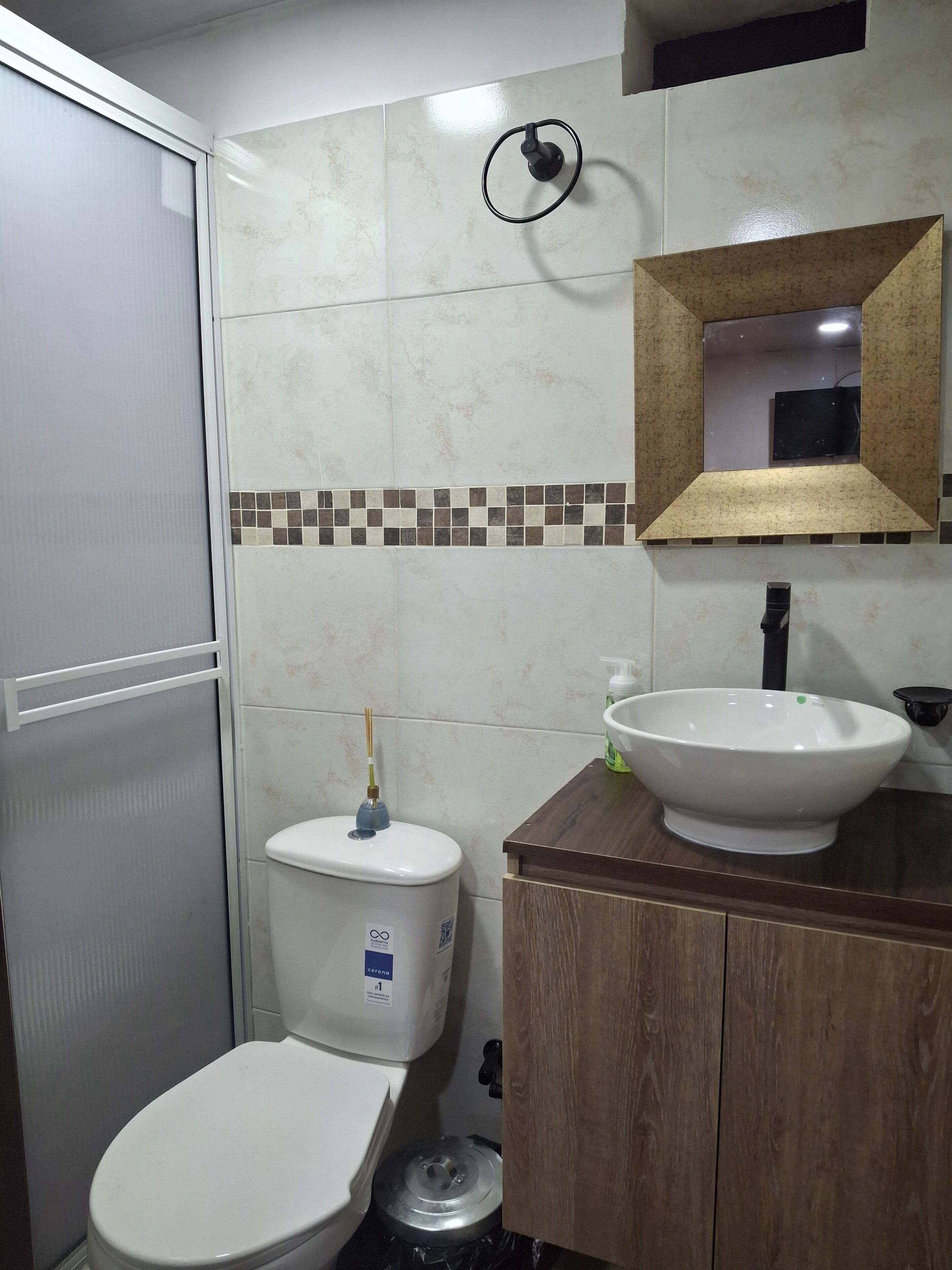 Un bagno con il water, un lavandino e uno specchio.