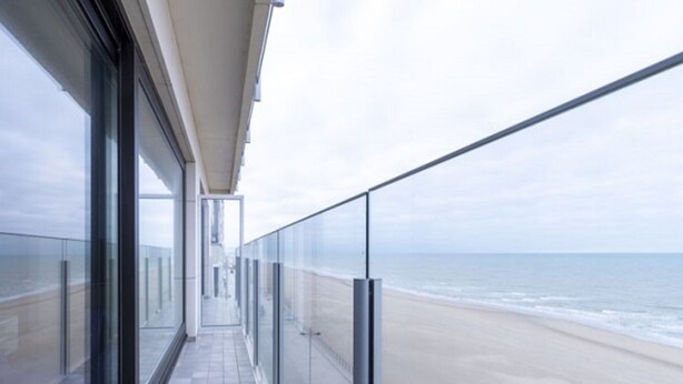 A balcony with a view of the beach.