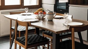 A dining area with a wooden table set for four, including plates, glasses, and a bowl of fruit. - Welcome to Annecy!<br>Enjoy a comfortable stay in our bright apartment, located in a quiet residential area. Just a 10-minute walk from the train station and the historic center, and 20 minutes from the lake — the perfect location to explore the city (Sévrier)