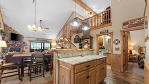 A spacious kitchen with wooden cabinets, a large island, and a dining area with chairs.