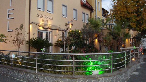 A hotel named "San Remo Hotel" with a traditional architectural style, featuring multiple windows and a well-lit entrance. - San Remo Fine.Food.Hotel (Nuremberg)