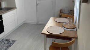 A modern kitchen with white cabinets, a built-in oven, and a window above the door.