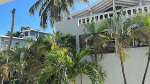 A building with a white exterior and a balcony with a railing. - Wind Chimes-Condo in Cabarete DR (Cabarete)