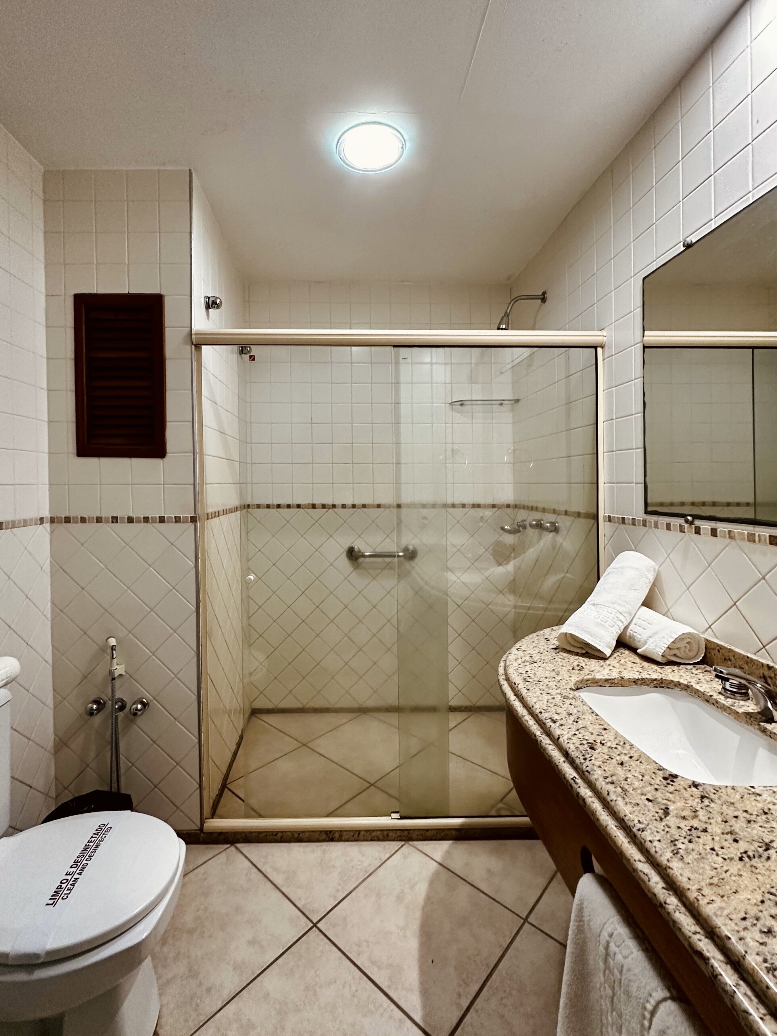 A bathroom with a shower, toilet, and sink.