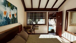 A bedroom with a bed, a desk, a chair, a painting, a ceiling fan, and a view of the outside. - Hotel Dominguez Plaza (Nova Friburgo)