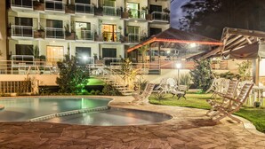 A hotel with a swimming pool, outdoor seating, and a covered area. - Hotel Dominguez Plaza (Nova Friburgo)