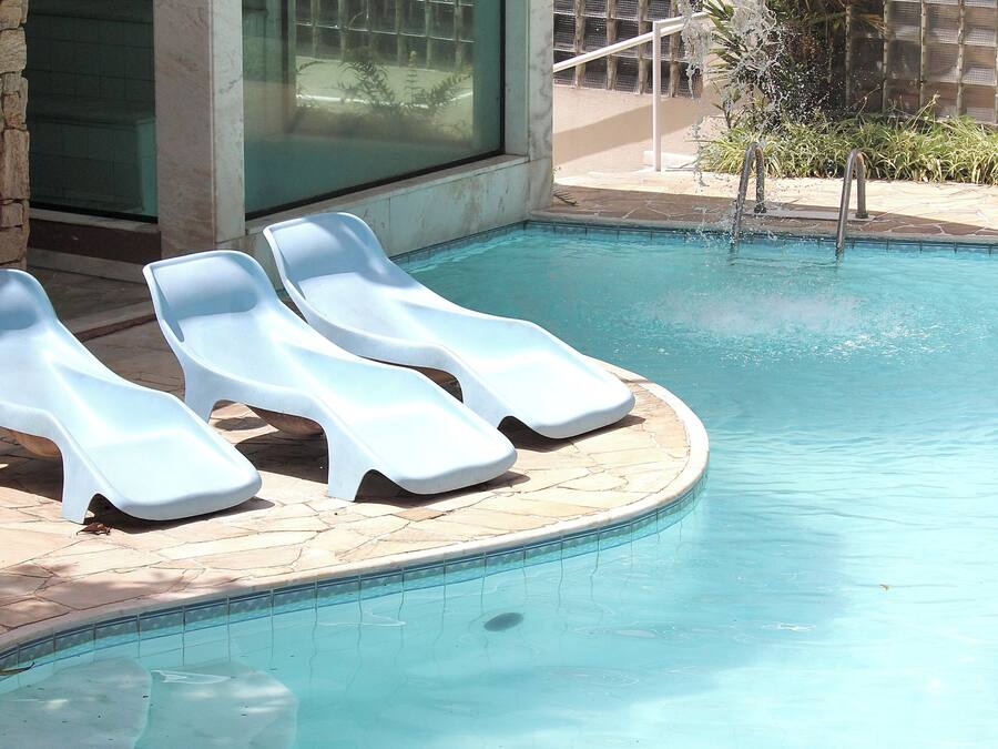 Alberca al aire libre, sombrillas en la alberca y camastros