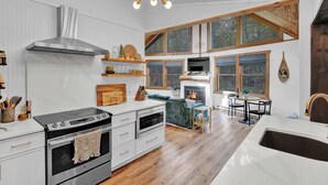 A modern kitchen with a large stove, oven, and a hanging light fixture.