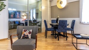 Un espace repas moderne avec des chaises à motifs, une table ronde et un luminaire décoratif.
