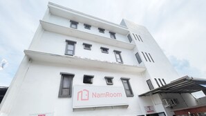 Un edificio a più piani con un'insegna per 'NamRoom' al piano terra.