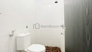 Un bagno con il water, una doccia e un lavandino.