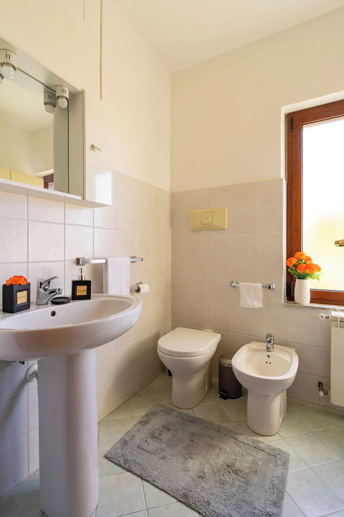 Ein Badezimmer mit Waschbecken, Toilette, Bidet und Spiegel.