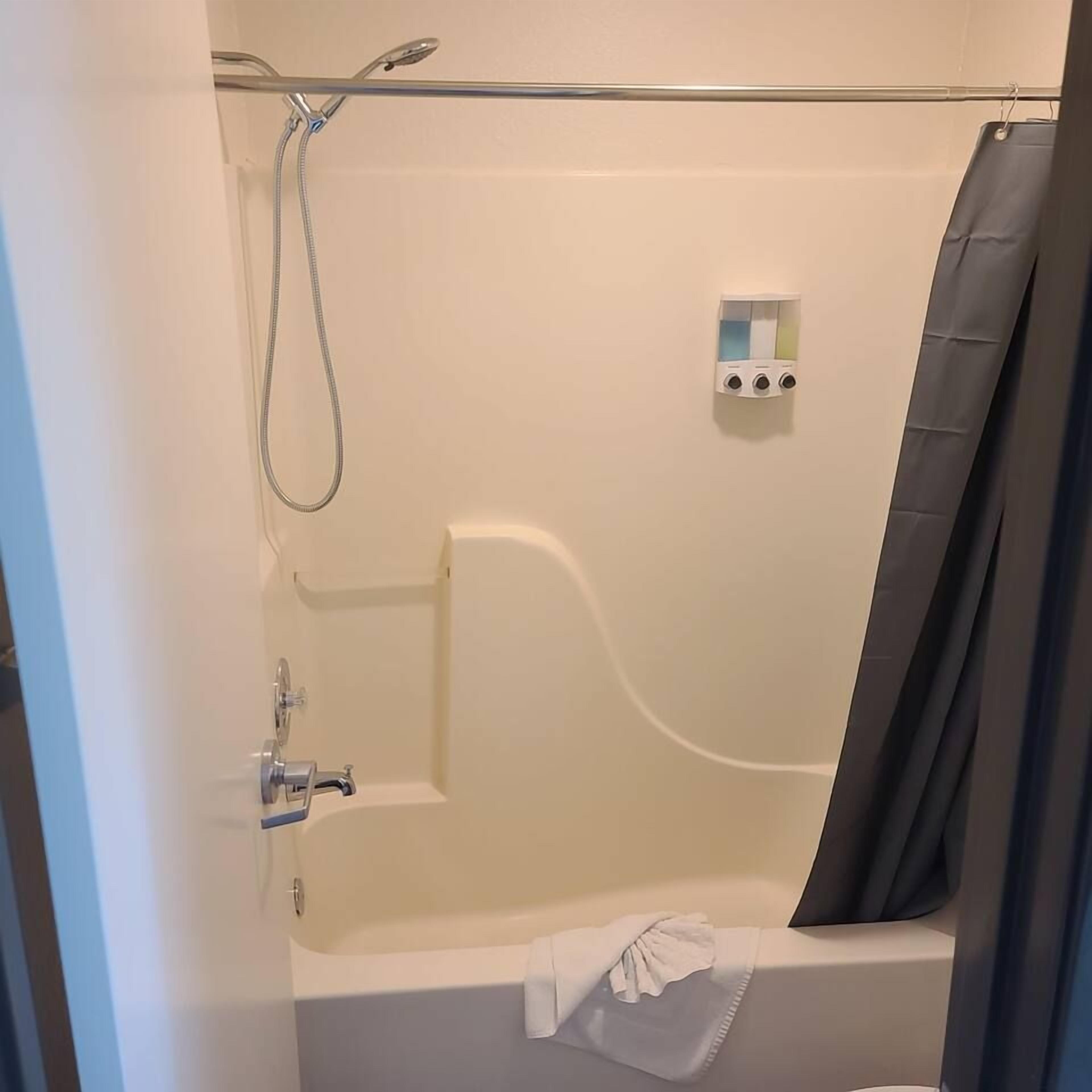 Un baño con bañera, ducha y panel de control.