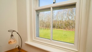 A room with a window overlooking a grassy field and trees. - Ol y Don, Newport - Three Bedroom Cottage, Sleeps 6 (Newport)