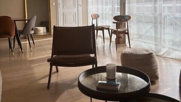A modern living room with a round coffee table, a brown armchair, and a small round table with a candle. - Stylish Apartment - 5 Min Walk to Center (L'Isle-sur-la-Sorgue)