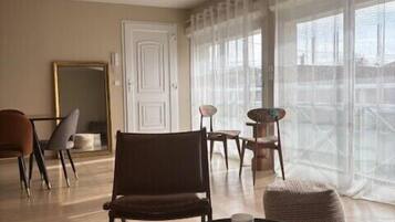 Un salon moderne avec une table basse ronde, un fauteuil marron et une petite table ronde sur laquelle est posée une bougie.