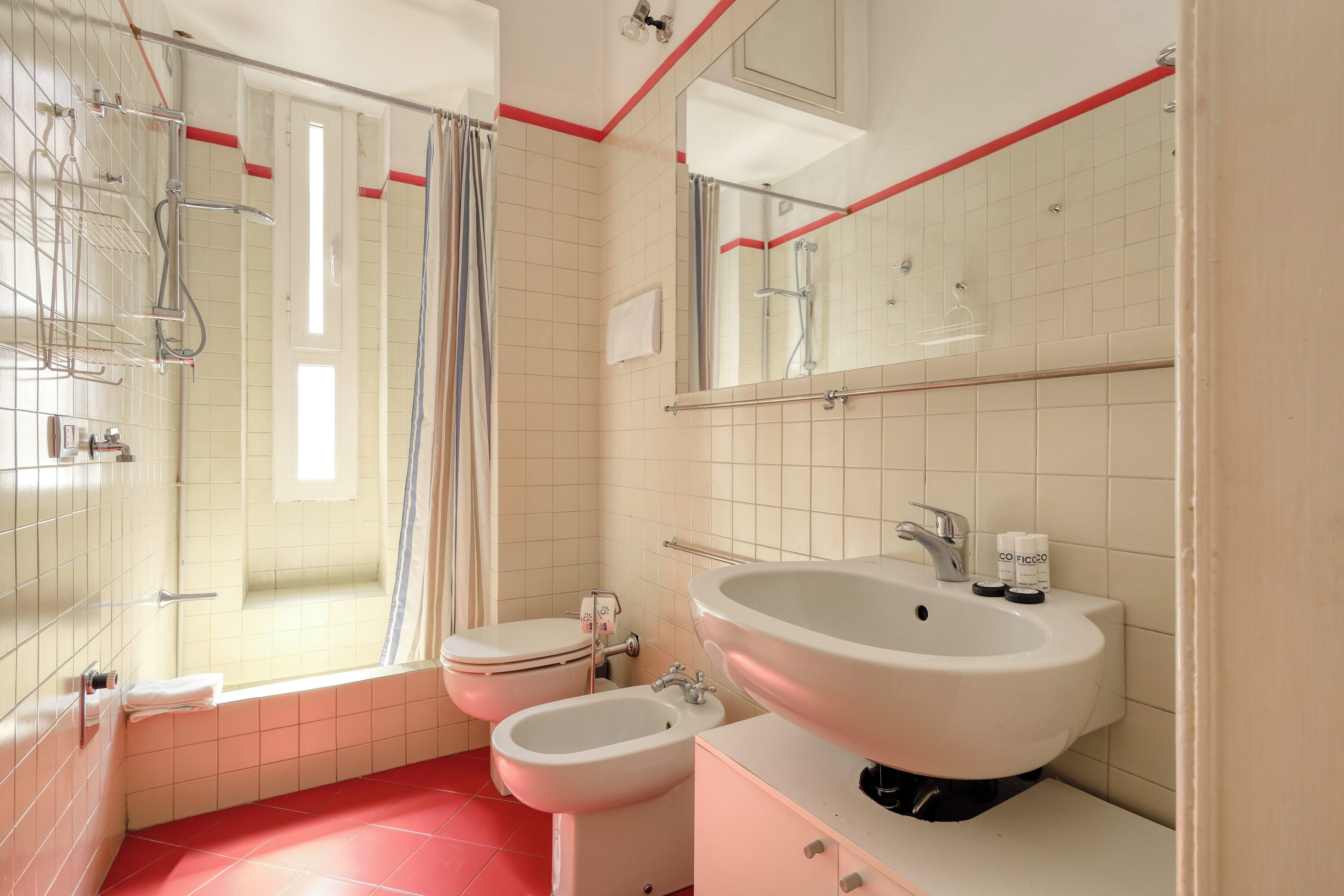 Une salle de bain moderne avec une baignoire, deux toilettes, un grand lavabo et un espace douche.