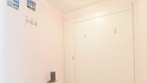 A room with a white door, a small trash bin, and two wall-mounted hooks. - Studio in Middelkerke Near Sea Wall (Middelkerke)